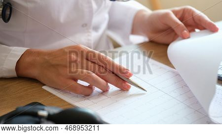 Doctor At Table In Office Examines Results Of The Patients Medical Tests. Close Up Of Doctor Diagnos