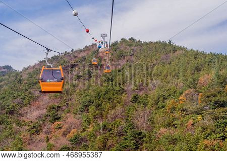 Hadong-gun, South Korea; November 24, 2022: Cable Cars Traversing Mountain Under Cloudy Sky