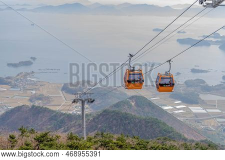 Hadong-gun, South Korea; November 24, 2022: Cable Cars Traversing Mountain On Foggy Day With Ocean I