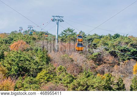 Hadong-gun, South Korea; November 24, 2022: Cable Cars Traversing Mountain Under Cloudy Sky