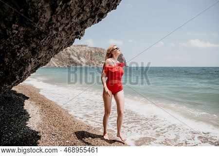 Young Woman In Red Bikini On Beach. Blonde In Sunglasses On Pebb