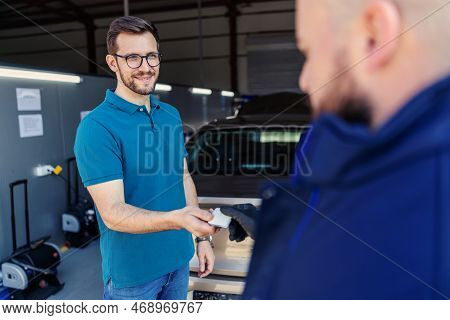 Handing Over The Keys At The Technical Inspection. The Client Leaves The Car Key To The Car Service 