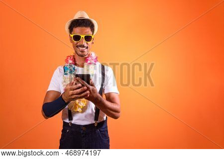 Portrait Of Black Man With Carnival Props Isolated On Orange Background.