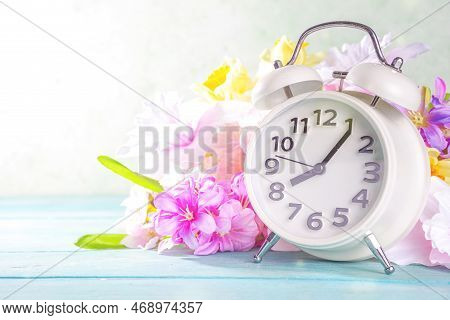Spring Time Change Concept. Summer Back Concept. Vintage Alarm Clock With Fresh, Beautiful Spring Fl