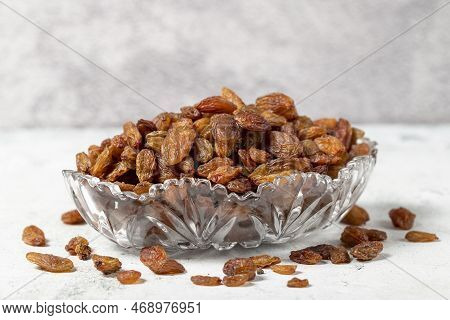 Dried apricots on stone background. Dark dried apricots in a glass bowl. Diet foods. close up