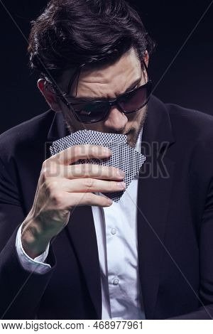 One Caucasian Brunet Pocker Player At Pocker Table With Chips While Thoughfully Sitting With Heap Of