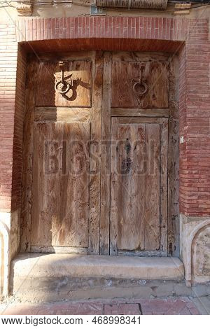 Biar, Alicante, Spain, January 14, 2023: Wooden Door With Dragon-shaped Knockers In Biar, Alicante, 