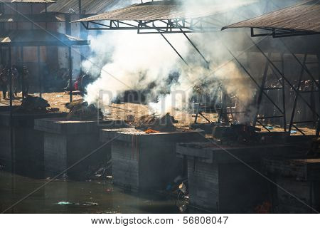 KATHMANDU, NEPAL - DEC 3: During the cremation ceremony along the holy Bagmati River in Bhasmeshvar Ghat at Pashupatinath temple, Dec 3, 2013 in Kathmandu, Nepal.