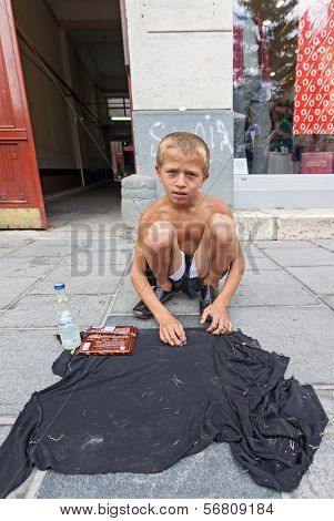 SARAJEVO, BOSNIA AND HERZEGOVINA - AUG 11: Sevdalija Osmanovic, 10 years old, sings on street to bypassers on August 11, 2012 in Sarajevo, B&H. He sings in order to provide money for his family.