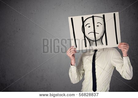 Businessman holding a paper with a prisoner in jail behind the bars on it in front of his head