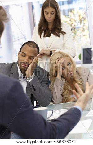 Boss talking to staff. Staff sitting bored.