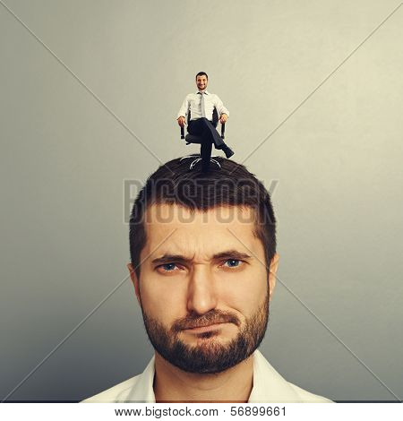 portrait of discontented man with happy successful man on the head