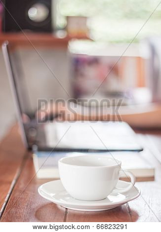Woman Using Laptop With A White Cup Of Coffee