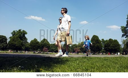 Family walking in a park under the blue sky