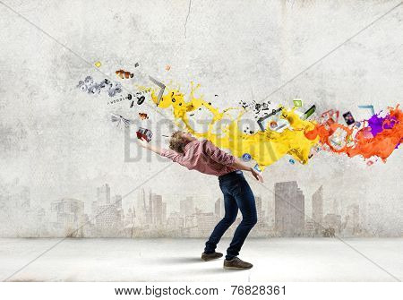 Young guy in casual evading from colorful splashes