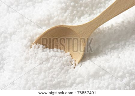 wooden spoon immersed in the portion of pure sea salt