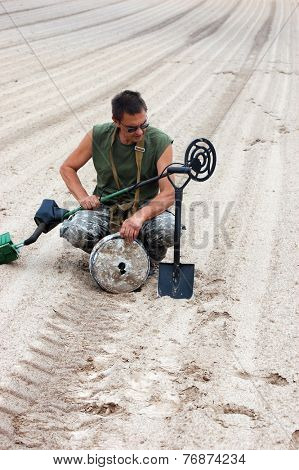 Kiev,Ukraine.June 3.Military archeology. Man with metal detector and German WWII anti tank landmine.At June 3,2012 in Kiev, Ukraine 