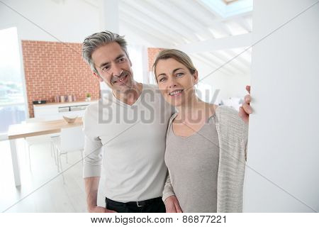 Mature couple opening door of their home