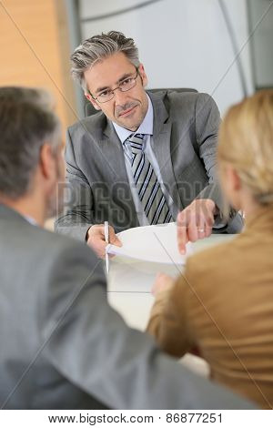 Mature couple signing contract in lawyer's office