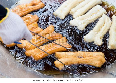 Deep frying bread stick or popularly known as You Tiao, a popular Chinese delicacy.