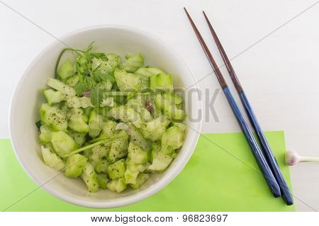 Salad With Cucumber And Marrow Squash With Parsley Onion And Oregano Next To Japanese Chopsticks On