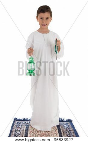 Young boy happily catching Ramadan lantern and rosary