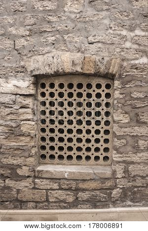 Stone lattice window of the walls of the ancient buildings close-up