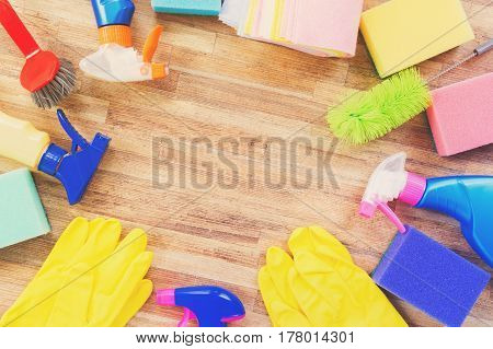 Spring cleaning concept - colorful sprays botles and rubbers frame, retro toned