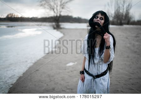 Crazy Young Woman Stands On Sand Along Lake.