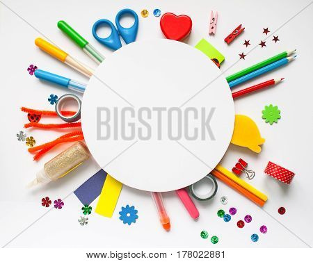 Round frame with stationery on the white background. Multicolor pencils and crayons. Place for your text.