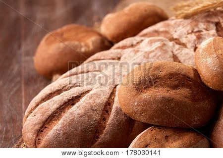 Assortement of fresh bread on the wooden table. Brown background. Brown bread. Close-up. Flour. Delicious food. Fresh baking. Tasty and appetizing.