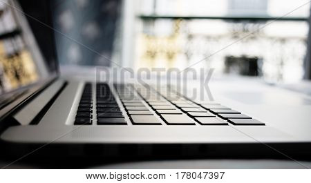 a laptop on the bed in the room in Paris writing fashion blog in Paris working at home or wathing movie on the bed. A silver laptop located on the bed near the window