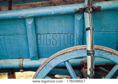 Old Retro Vintage Wooden Trailer With Blue Wheel Close Up, Detail. Countryside View On The Farm