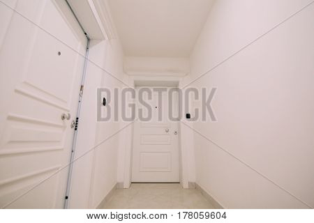 Corridor in a building. White staircase. Interior hallway with doors to the neighbors.