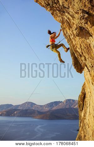 Female rock climber falling off cliff while lead climbing chipped off piece of cliff falling near woman's foot