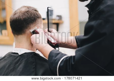 Barber cuts the client mac Haircut men Barbershop. Men's Hairdressers; barbers.