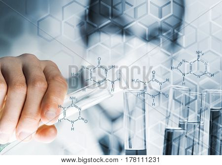 Young scientist mixing reagents in glass flask in clinical laboratory