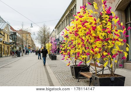 UPPSALA SWEDEN - Mar 26 2016 - Street view of traditional colourful feathers on trees for Easter decorations in Uppsala Sweden Europe