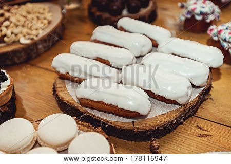 Eclairs traditional french dessert. Yellow wooden table candybar