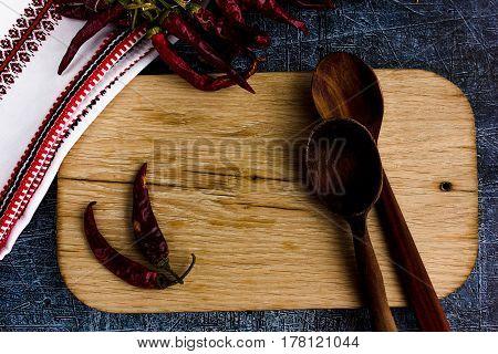 Rural kitchen board  With wooden spoons and old weave from above - grunge background with free text space. concrete background.  Different stuff. Top view. Copy space.