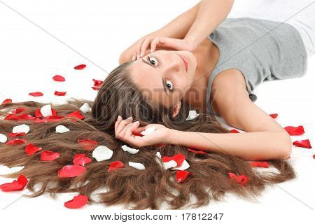 junge schöne Brünette Frau mit verstreuten langen Haaren und ros