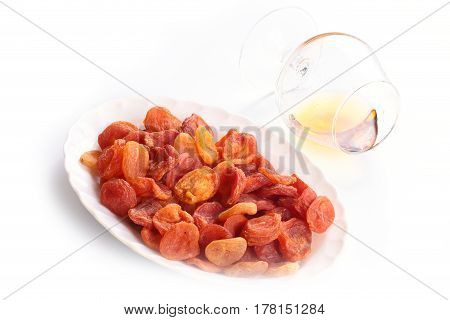 Fresh ripe dried fruits apricots and a glass of alcoholic beverage