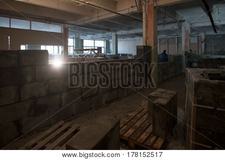 View of a premise being repaired with builders working and walls of aerated concrete in construction