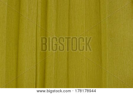 Dark yellow background of a roll of crumpled paper