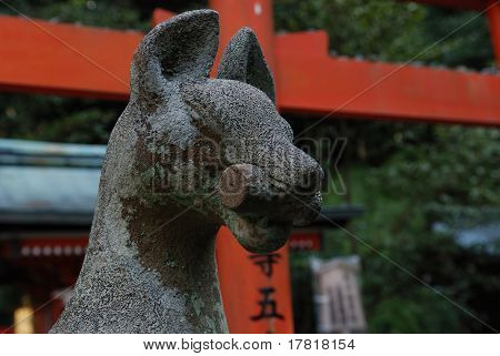 รูปปั้นสุนัขจิ้งจอกผู้ปกครองหรือคิสึเนะที่ Fushima Inari ศาล เกียวโต ญี่ปุ่น