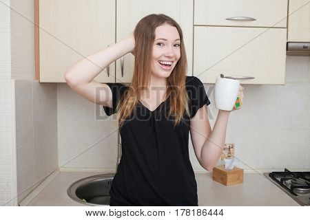 Beautiful young woman having morning coffee, relaxing hot drink, happy female holding cup of tea, pretty girl eating and drinking healthy food at home, health care and dieting concept.