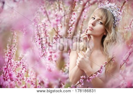 portrait of a beautiful blonde girl in a flowering garden