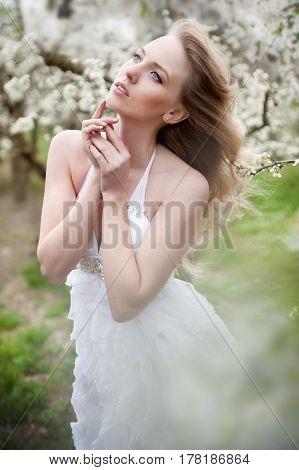 portrait of a beautiful blonde girl in a flowering garden