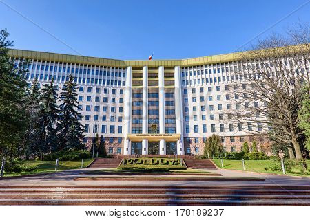 Parliament of the republic of moldova in chisinau, national flag, stefan cel mare street, spring time with blue sky