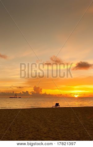 Lyse solopgang i morgen med sandstrand og havet